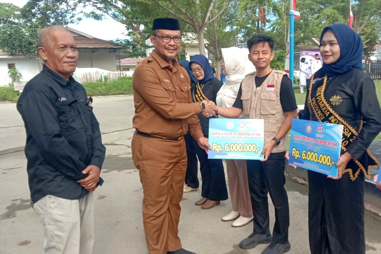 Staf Ahli Gubernur Bidang Pemerintahan, Hukum, dan Politik, Masran Rauf, menyerahkan secara simbolis bonus kepada pemuda pemudi berprestasi pada upacara peringatan Hari Sumpah Pemuda ke-97 di halaman kantor Dinas Pemuda dan Olahraga