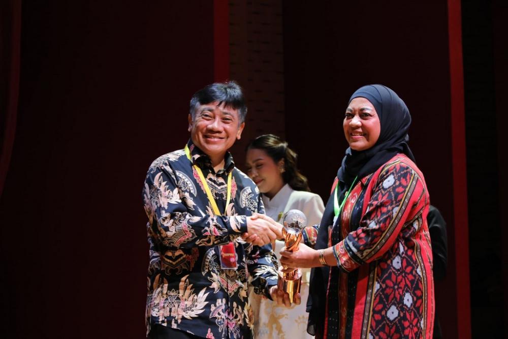 Deputi Bidang Pembangunan Kewilayahan Bappenas Medrilzam (kiri), menyerahkan tropi Bhumandal Batang Sri Purwaningsih di Perpustakaan Nasional RI Jakarta Pusat.