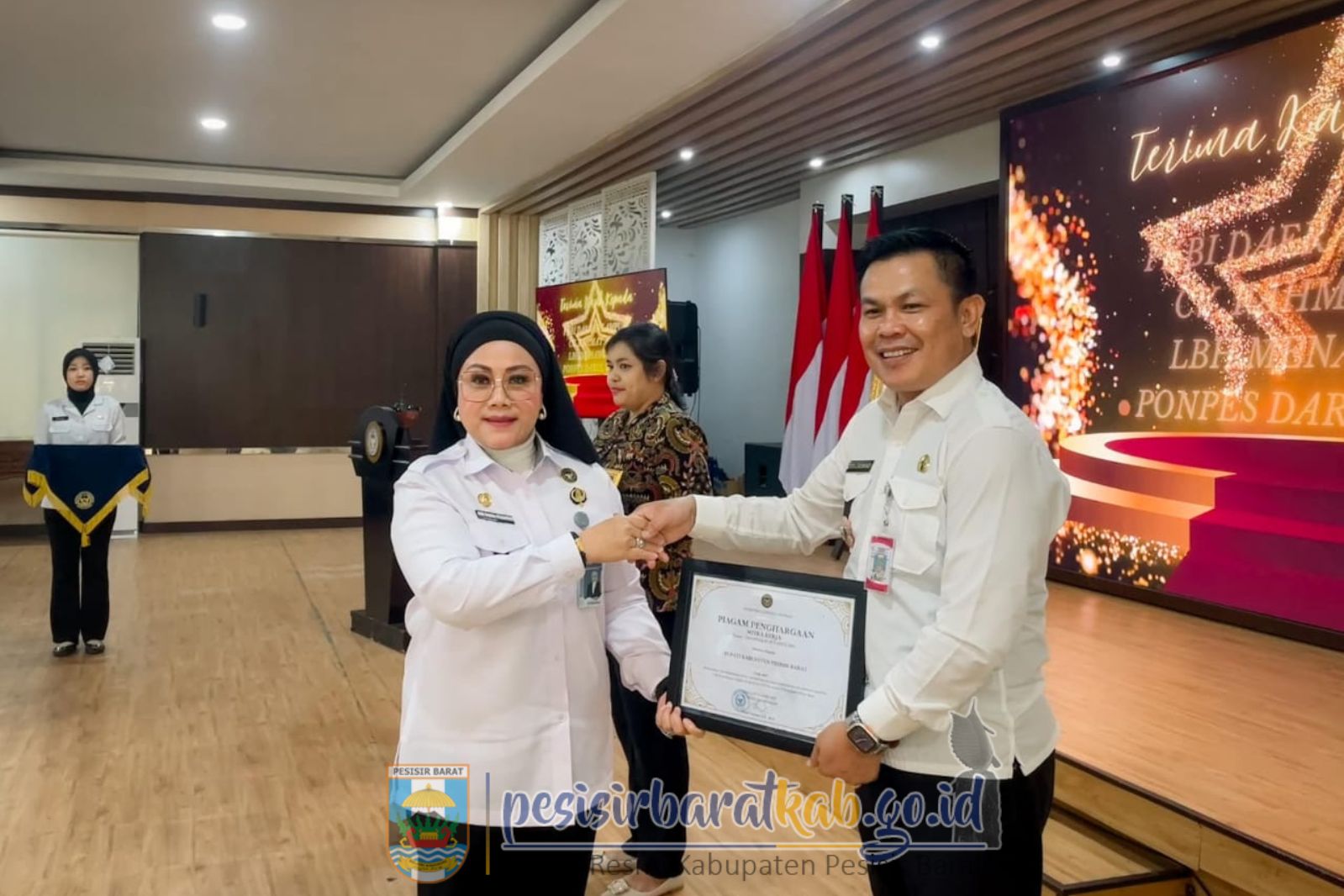 Sekretaris Daerah Kabupaten Pesisir Barat, Tedi Zadmiko, S.K.M., S.H., M.M., menerima penghargaan mewakili Bupati Pesibar