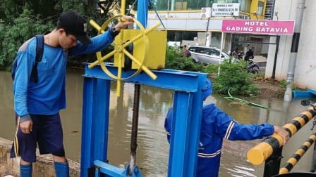 petugsa sedang memeriksa rumah pompa dan pintu air