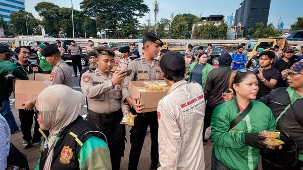 Momen Polisi Bagikan Air Mineral dan Roti ke Massa Buruh dan Ojol di DPR